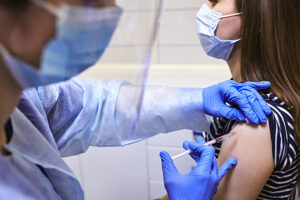 Medical provider administering a tetanus shot to a female patient