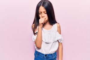 Young girl feeling unwell and coughing