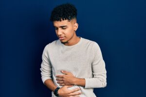 Young man holding his painful stomach